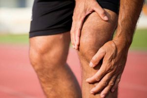 man-holding-knee-in-pain-due-to-patellofemoral-syndrome-or-runners-knee-featured-e1611003623126