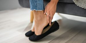 iStock-1194077382_woman-feeling-heel-in-black-flats_blog
